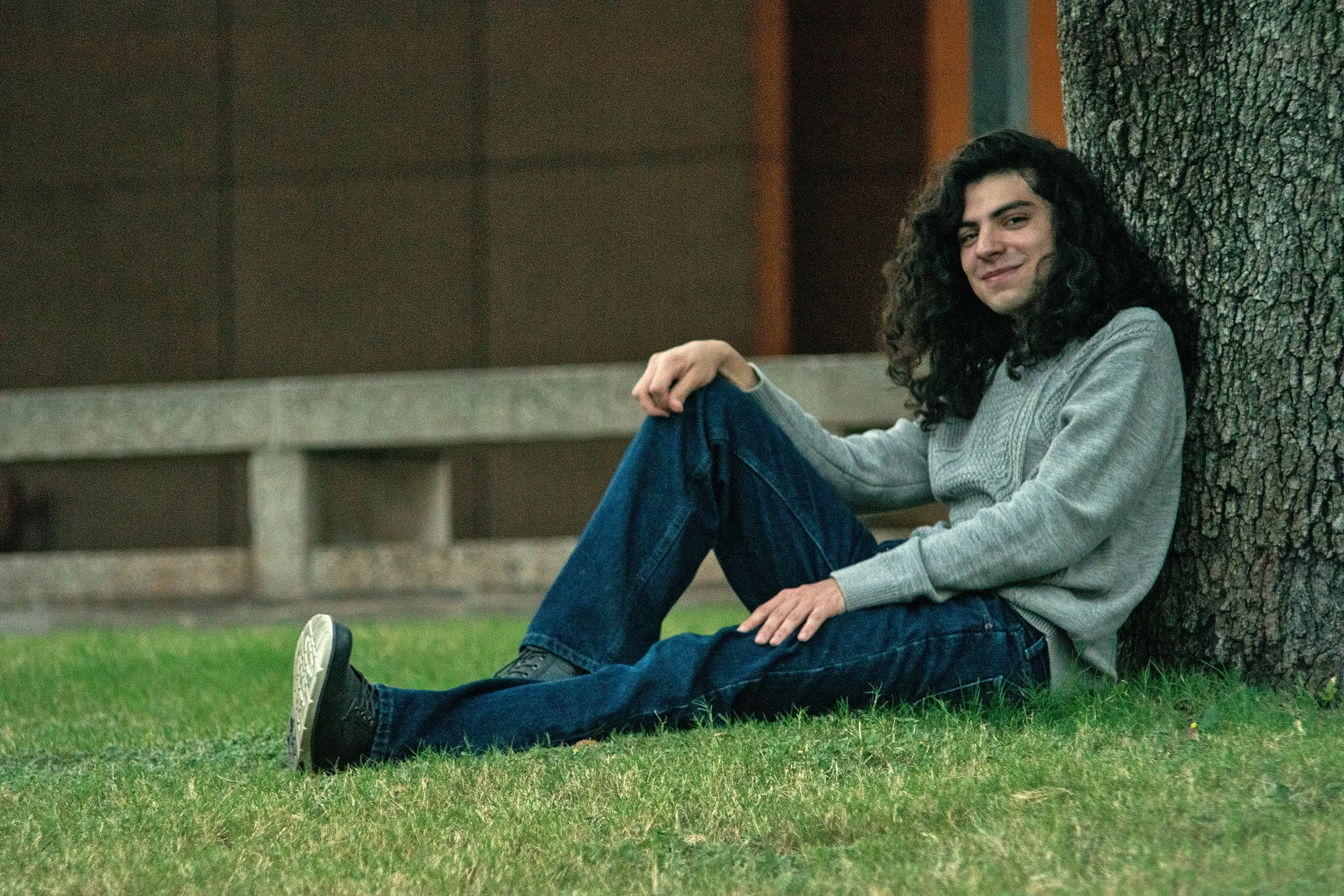 A portrait of myself sitting on the grass beside a tree